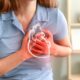 Close-up of woman clutching chest with animated picture of heart while suffering heart attack symptoms