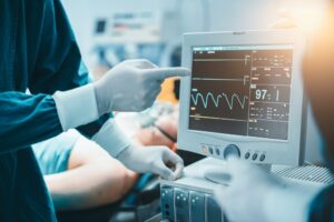 Doctor points at an electrocardiogram on a computer monitor